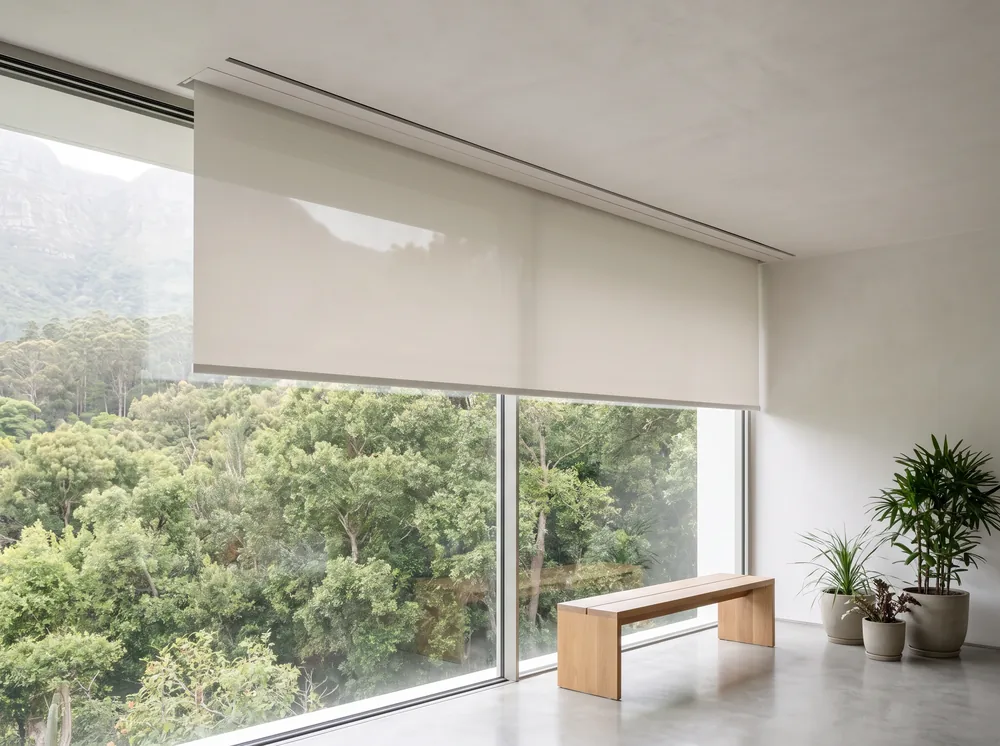 Flat roller blind emerging from a concealed ceiling-recess headbox above floor-to-ceiling glass in a Newlands home